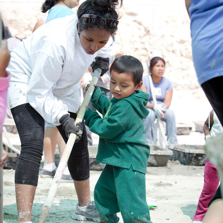 Female student helps a boy during a service project